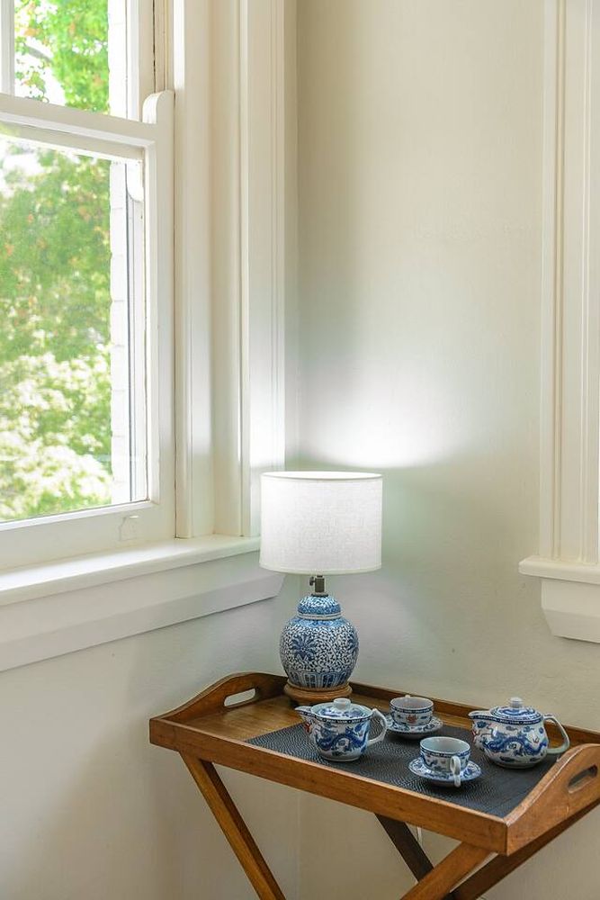 Side table with a lamp and a tea set by the window