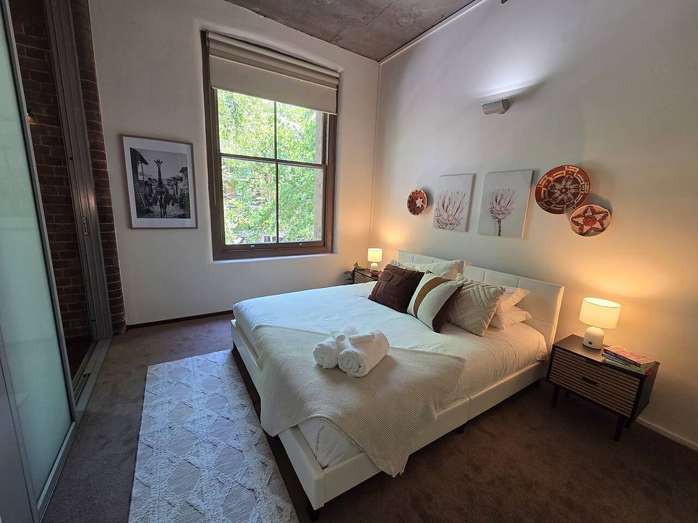 Bedroom with bedside tables and a window to the trees