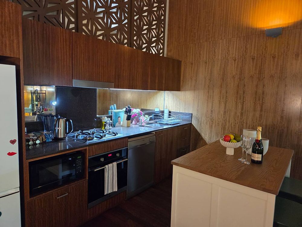 Timber kitchen with a black benchtop, oven and island