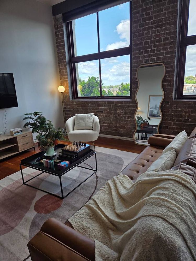 Armchair and coffee table beside the brick wall and window
