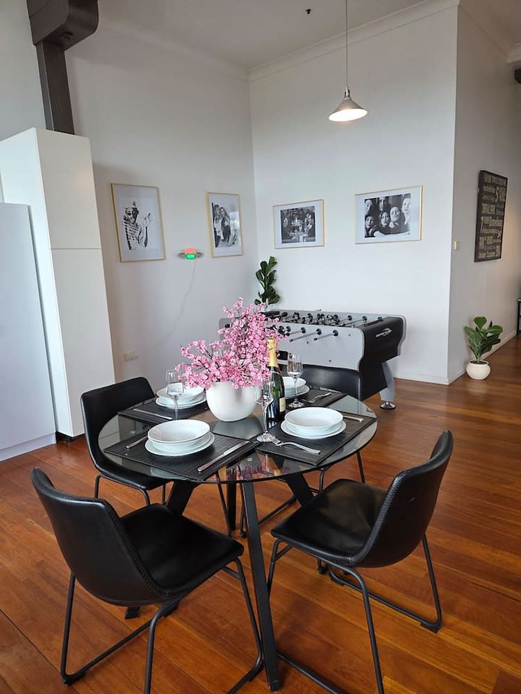 Round glass dining table with black chairs