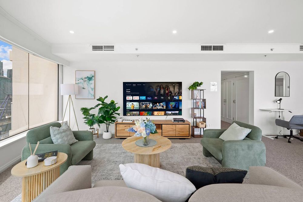 Living room with three two-seater sofas and a TV